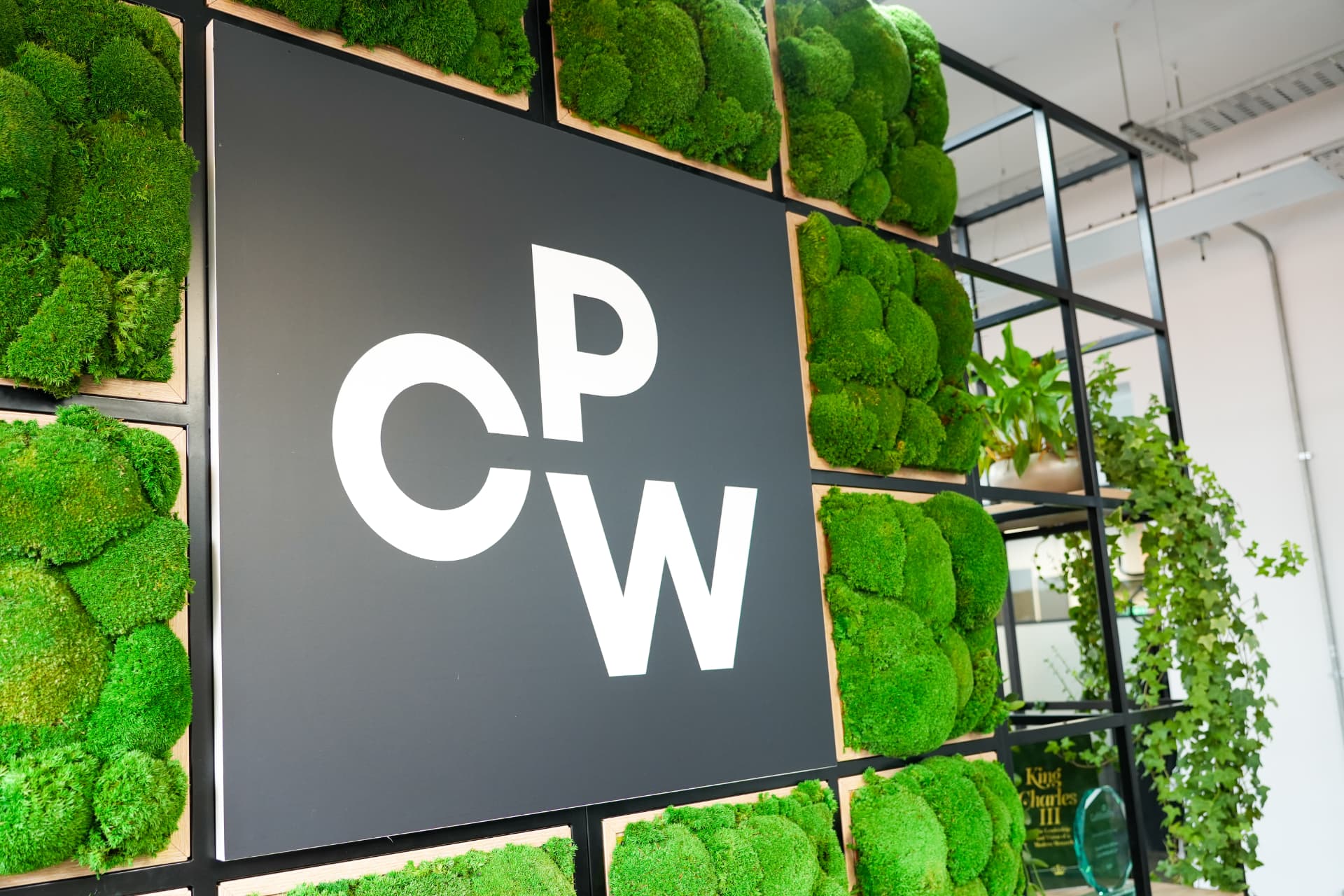 CPW logo sign mounted on a moss wall in the office