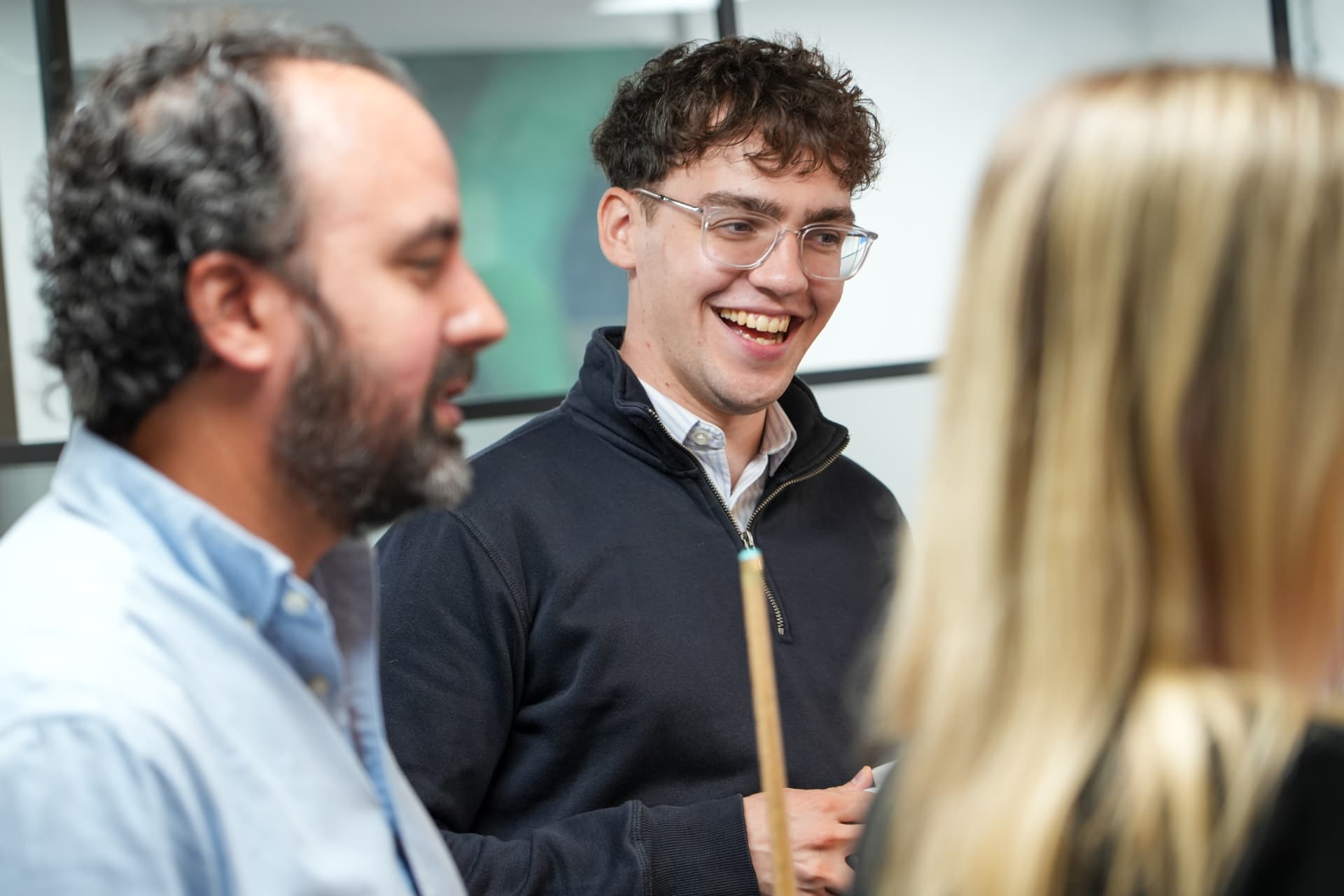 CPW colleagues laughing together during a conversation in the office