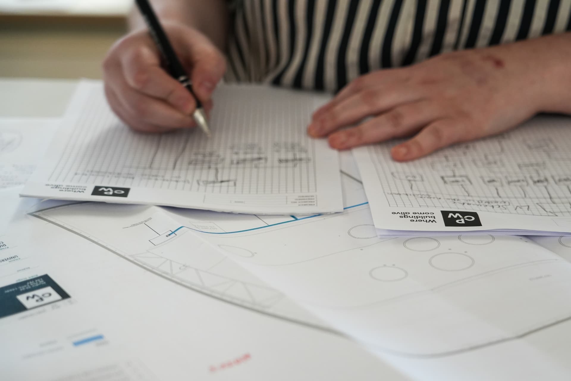 An engineer marking up technical drawings by hand