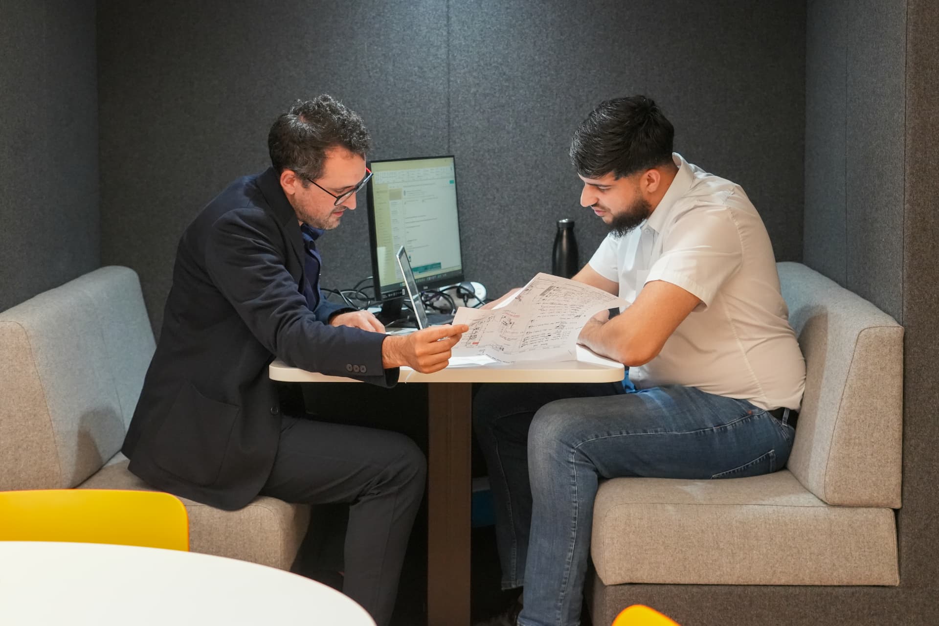 Two CPW colleagues reviewing drawings together in a meeting booth